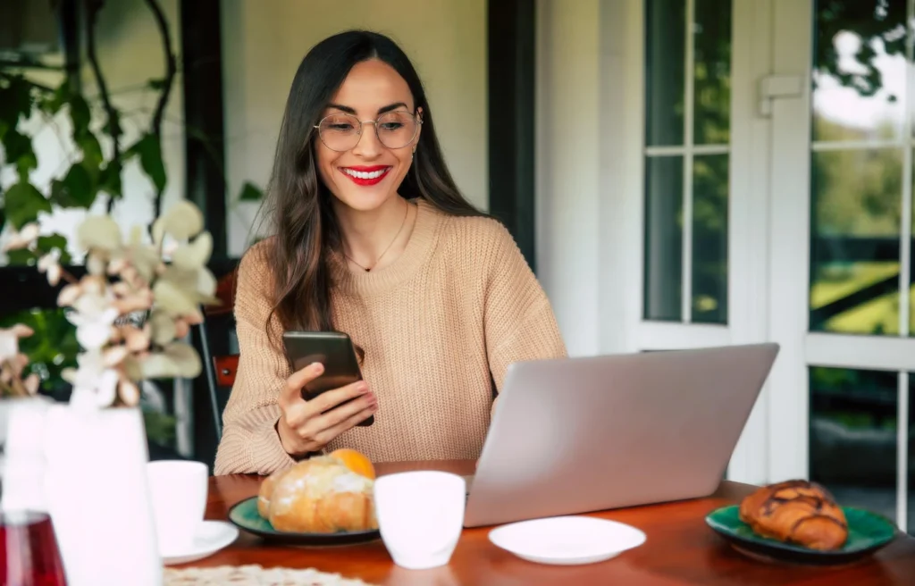 Mujer usando smartphone para enviar remesas desde Nueva York a Guatemala sin comisiones